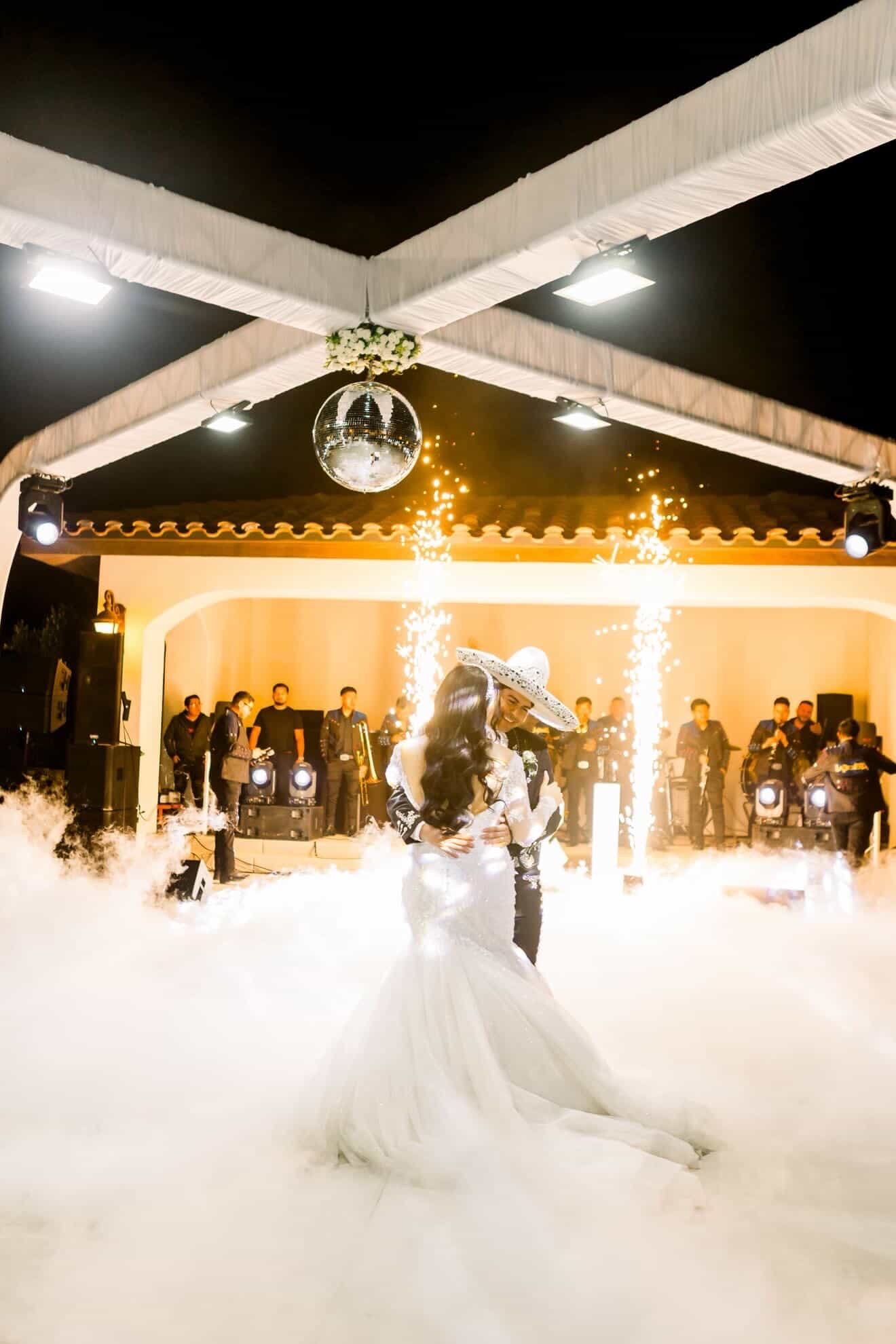 Bride and groom first dance with sparklers and dance floor smoke at Rancho Escondido wedding in Indio.